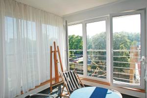 Zimmer mit 2 Stühlen, einem Tisch und Fenstern in der Unterkunft Apartament Słoneczne Gniazdko z miejscem parkingowym GRATIS cena niższa przy pobycie od 6 dni in Sopot