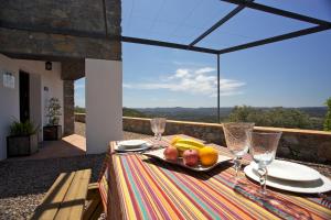 a table with a plate of fruit and wine glasses at Las Tobas in Higuera de la Sierra