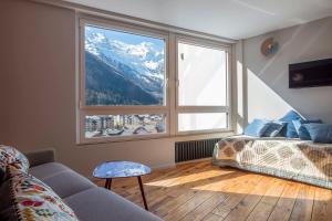 1 dormitorio con cama y ventana grande en Modern Studio With Mont Blanc View And Pool, en Chamonix-Mont-Blanc