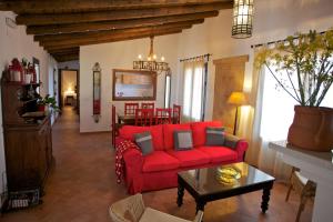 a living room with a red couch and a table at Las Tobas in Higuera de la Sierra