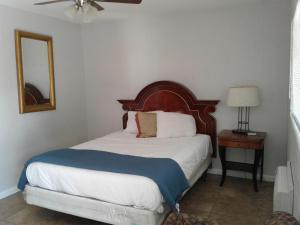 a bedroom with a bed and a table with a mirror at Sterling Gardens in Las Vegas