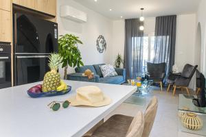a living room with a table with a bowl of pineapple at Andreotis Villas in Protaras