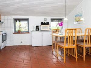 Il comprend une cuisine équipée d'une table, de chaises et d'un four micro-ondes. dans l'établissement 6 person holiday home in Hejls, à Hejls