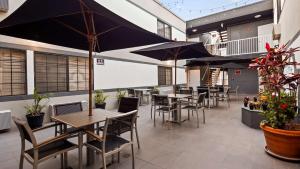 a restaurant with tables and chairs and umbrellas at SureStay Hotel by Best Western Beverly Hills West LA in Los Angeles