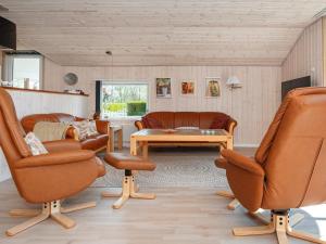 uma sala de estar com cadeiras de couro e uma mesa em 8 person holiday home in Hejls em Hejls