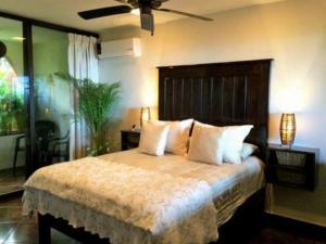 una camera da letto con un letto e un ventilatore a soffitto di Vista de las Rocas a Ixtapa Altre 12 foto