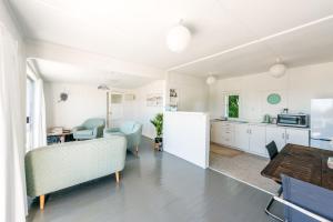 a kitchen and living room with a table and chairs at Roses Bach in Onetangi