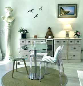 a dining room with a glass table and birds on the wall at ANTINEA in Cassis