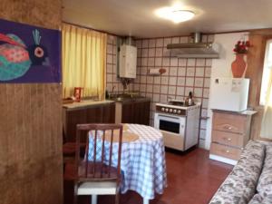 a small kitchen with a table and a stove at Cabaña Cerezo in Guayacán