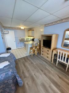 a room with a bed and a kitchen with a table at Beau Rivage Motel in Old Orchard Beach