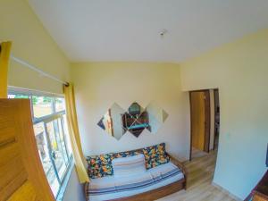 a living room with a couch and a window at Beco das Flores in Carrancas