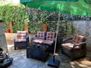 布爾加斯的住宿－Бургасский дом，庭院里摆放着一组椅子和一把遮阳伞