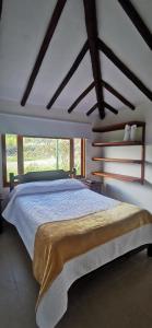 a bedroom with a large bed and a large window at Villa Monica HR in Villa de Leyva