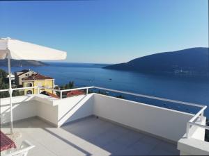Biały balkon z widokiem na wodę w obiekcie Apartments Zora i Veselin w mieście Herceg Novi