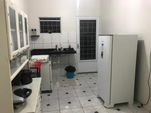 uma cozinha com 2 frigoríficos e piso em azulejo em Olga Moreira 01 - inclui garagem em Paragominas