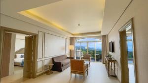 a living room with a couch and a room with a bed at Twin Lakes Hotel in Tagaytay
