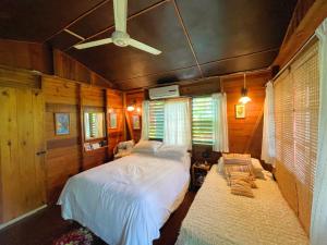 a bedroom with a bed and a ceiling fan at Judy House Cottages And Rooms in Negril