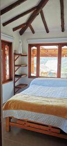 a bedroom with a large bed and windows at Villa Monica HR in Villa de Leyva