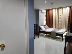 1 dormitorio con 1 cama en una habitación con ventana en RedDoorz @ Villa E Mansion, en Vigan
