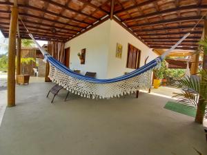 a hammock in the middle of a porch at Recanto Verde - Praia de Santo Antônio in Diogo