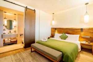una camera con letto verde e un bagno di Jinling Onejoy Hotel a Nanjing
