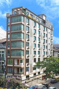 仰光大联合酒店 - 唐人街的一座高大的白色建筑,上面有标志