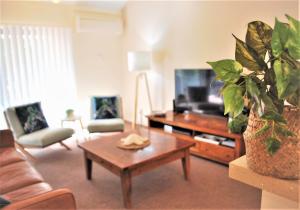 a living room with a couch and a coffee table at Outrigger Bay in Byron Bay