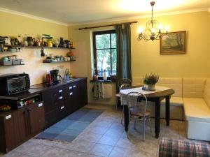 cocina y comedor con mesa y sofá en Holiday Home NIGLINI, en Saunags