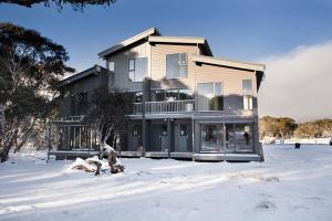 a house with snow in front of it at Schoren in Dinner Plain