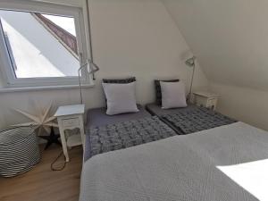 ein kleines Schlafzimmer mit 2 Betten und einem Fenster in der Unterkunft BodenSEE Apartment Friedrichshafen B 19 in Friedrichshafen