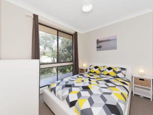 A bed or beds in a room at Ripple Cove @ Fingal Bay