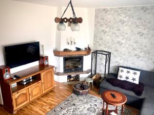 a living room with a television and a fireplace at Wind Rose apartment in Kuressaare