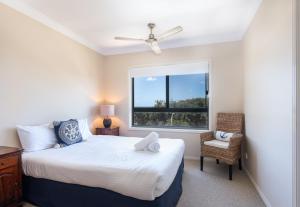 a bedroom with a bed and a window at Breakers Unit 1 10 - LJHooker Yamba in Yamba +5 photos