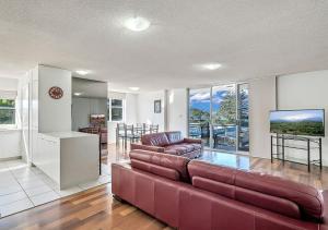 uma sala de estar com um sofá e uma mesa em Tradewinds Apartments em Coffs Harbour