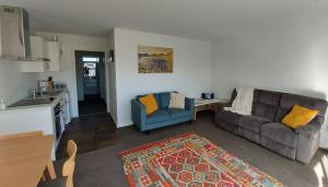 a living room with a couch and a kitchen at LAKE ESCAPE - Warm quiet and spacious two bedroom Apartment in Otematata