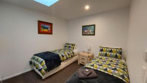 a bedroom with two beds and a chair in it at LAKE ESCAPE - Brand new warm and quiet two bedroom Apartment in Otematata