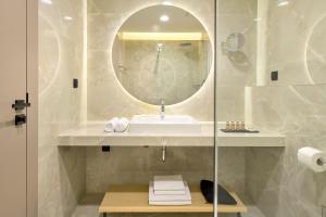 a bathroom with a sink, mirror, and bath tub at Boutique Hotel Porto in Dubrovnik