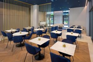 a restaurant with white tables and blue chairs at Boutique Hotel Porto in Dubrovnik