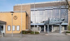 un bâtiment en briques avec un panneau devant lui dans l'établissement Hotel am Stadtpark, à Borken