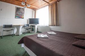 a hotel room with a bed and a flat screen tv at Pokoje Goscinne Korsarz - przy trasie rowerowej R10 in Ustka +25 photos