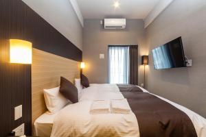 Postel nebo postele na pokoji v ubytování HOTEL SUITE HIROSHIMA YOKOGAWA