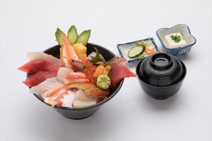 a bowl of sushi and a container of soy sauce at Kur and Hotel Isawa in Fuefuki