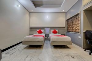 two beds with red pillows in a room at OYO 1545 Hotel Shivani International in Ahmedabad