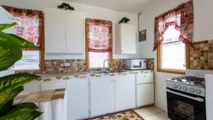 a kitchen with white cabinets and a stove at Moonlight Cottage in East End Village