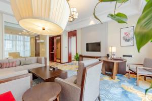 a living room with a couch and a table at Binhai Jinling International Hotel in Binhai