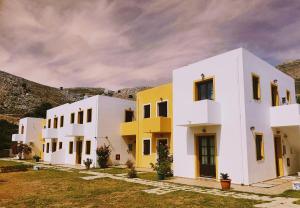 
a white building with a blue roof and white walls at Tilos Fantasy in Livadia
