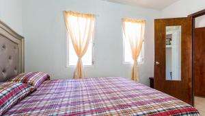 a bedroom with a bed and two windows at Moonlight Cottage in East End Village