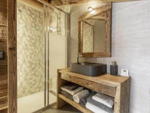 ein Badezimmer mit einem Waschbecken, einem Spiegel und Handtüchern in der Unterkunft Chalet La Clusaz, 5 pièces, 11 personnes - FR-1-304-229 in La Clusaz
