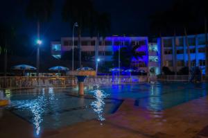 a swimming pool at night with blue and purple lights at Hotel Bachue Girardot in Girardot