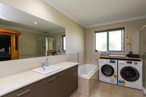 a bathroom with a washing machine and a sink at Riverside Haven in Healesville